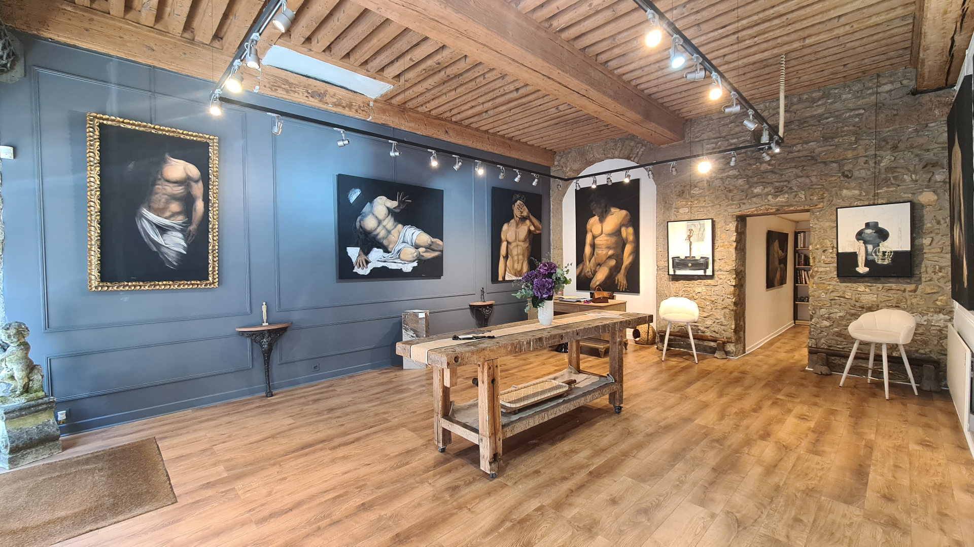 Intérieur de la Galerie AINAY, murs en pierre et poutres apparentes